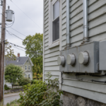 A row of electricity meters and boxes on the side wall of a house